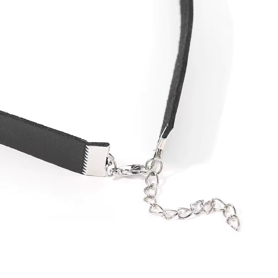 Close-up of a silver chain necklace with a black ribbon on a white background